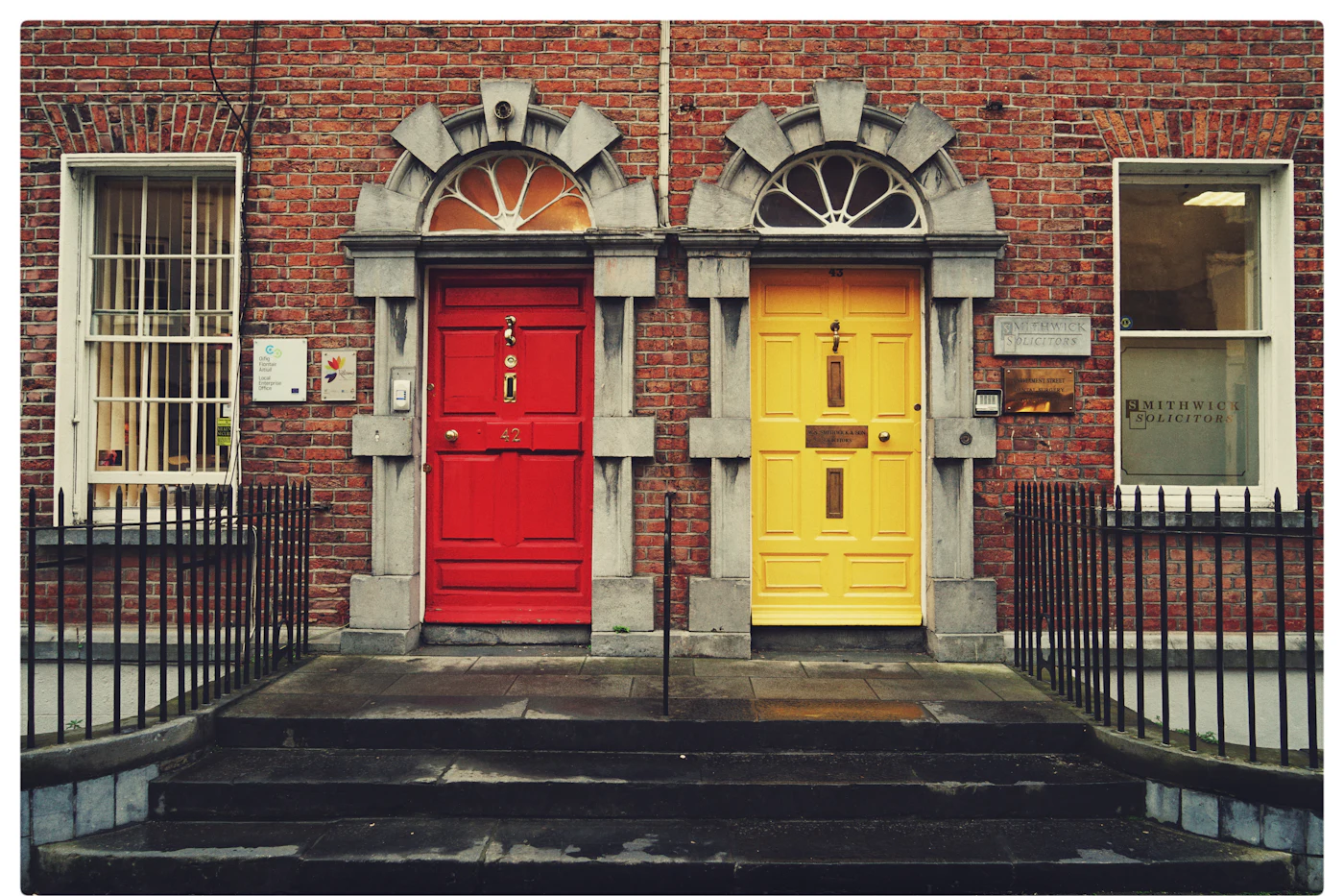 Two Georgian front doors in Dublin, one red and one yellow, with fanlights above